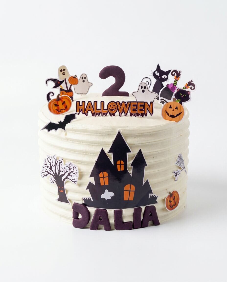 Pastel redondo de buttercream blanco con textura horizontal, casa embrujada negra con ventanas naranjas, árbol seco, telaraña, calabaza, nombre 'DALIA' en fondant morado y topper de Halloween con fantasmas, gato negro, calabazas, bruja y número 2